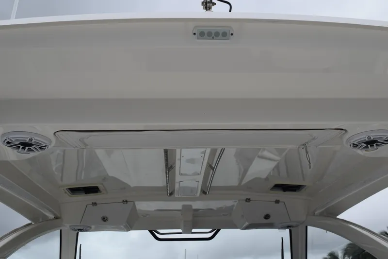 Slide: The Image of 2022 Pursuit OS 355 Offshore boat with white cushioned seating and triple outboard motors. - 49