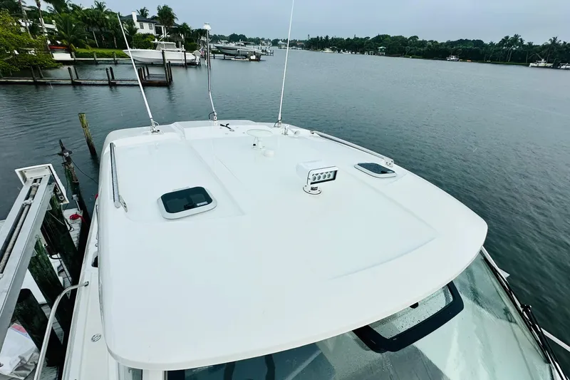 Slide: The Image of Open refrigerator inside 2022 Pursuit OS 355 Offshore boat, featuring wooden interior design. - 7