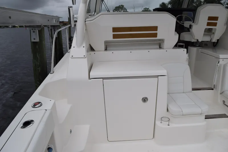 Slide: The Image of 2022 Pursuit OS 355 Offshore boat interior with seating and docked at marina. - 96