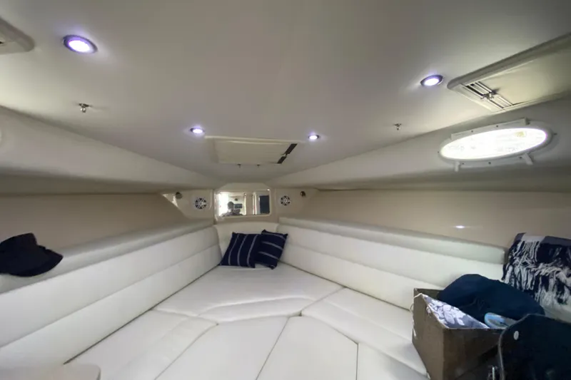 Slide: The Image of Interior cabin of 2014 Wellcraft 340 Coastal boat, featuring white seating and ambient lighting. - 19