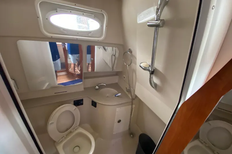 Slide: The Image of 2014 Wellcraft 340 Coastal boat bathroom with shower, sink, and toilet. - 21