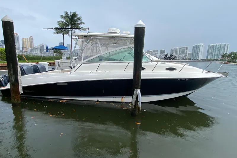 Slide: The Image of 2014 Wellcraft 340 Coastal boat docked in a marina with cityscape background. - 27