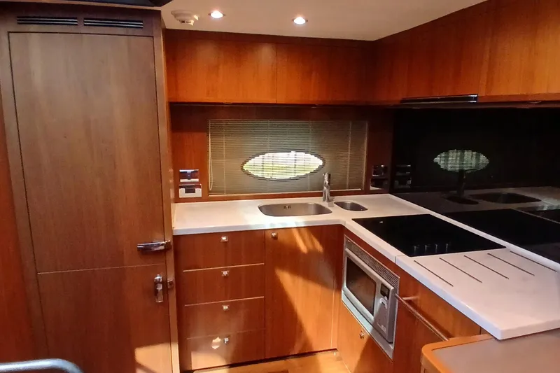Slide: The Image of Luxurious 2015 Princess V62-S yacht kitchen with modern wood cabinetry and sleek appliances. - 13