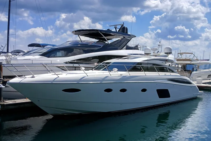 The Image of Luxury 2015 Princess V62-S yacht docked at marina under blue sky. - 0