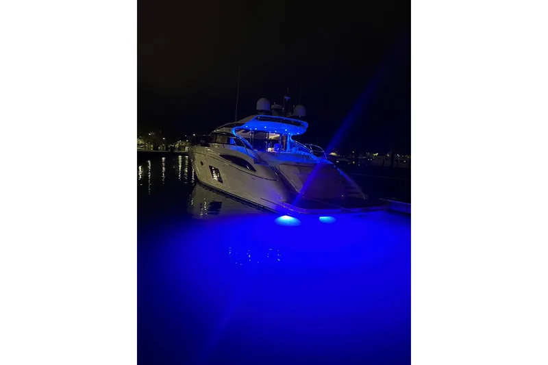 Slide: The Image of 2015 Princess V62-S yacht illuminated with blue lights at night. - 4