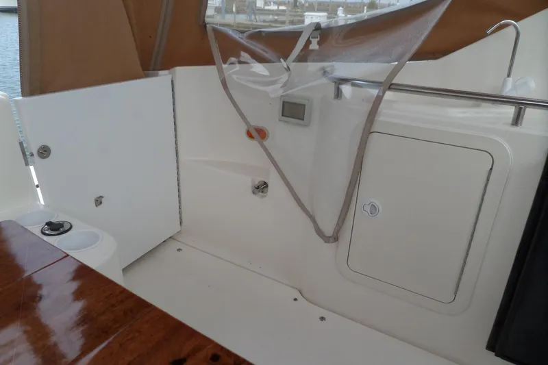 Slide: The Image of 2003 Cruisers Yachts 3275 Express interior with storage compartments and wooden table. - 11