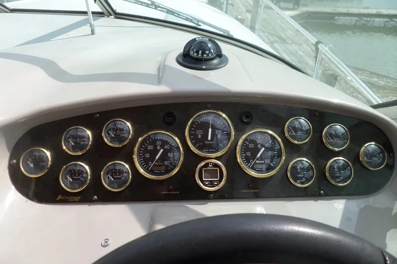 Slide: The Image of Dashboard of a 2003 Cruisers Yachts 3275 Express with various gauges and a compass. - 14