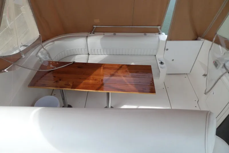 Slide: The Image of 2003 Cruisers Yachts 3275 Express interior with wooden table and white seating. - 30