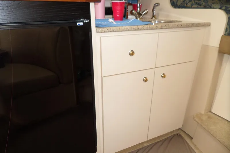 Slide: The Image of 2003 Cruisers Yachts 3275 Express interior with sink, cabinets, and mini fridge. - 33