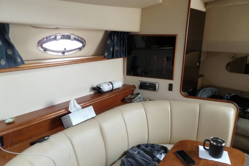 Slide: The Image of Interior of 2003 Cruisers Yachts 3275 Express with seating, porthole, and table. - 39