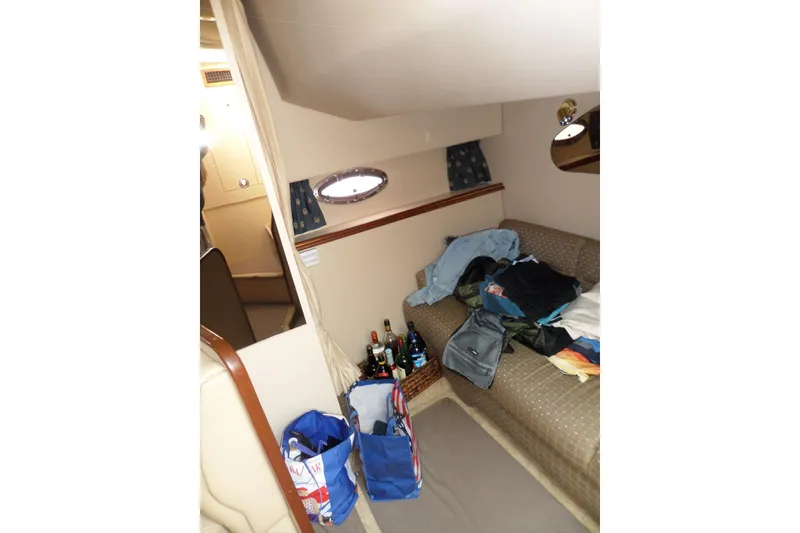 Slide: The Image of Interior of 2003 Cruisers Yachts 3275 Express with sofa, clothes, and bags. - 43