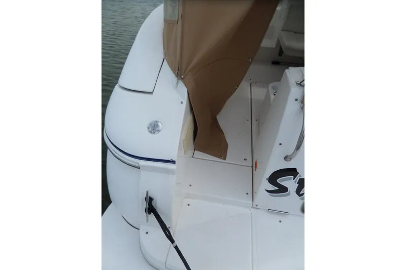 Slide: The Image of 2003 Cruisers Yachts 3275 Express boat deck with tan cover, docked on water. - 5