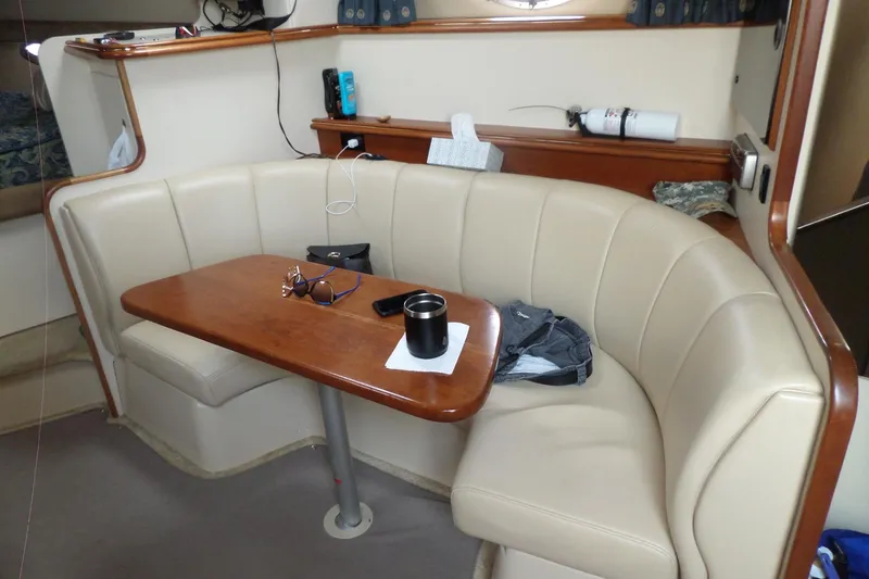 Slide: The Image of Interior of 2003 Cruisers Yachts 3275 Express with beige seating and wooden table. - 50