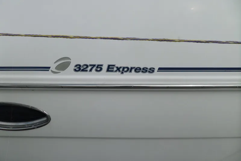 Slide: The Image of 2003 Cruisers Yachts 3275 Express boat side view with logo and stripe detail. - 3