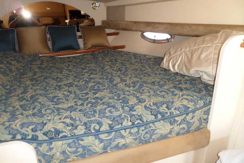 Slide: The Image of 2003 Cruisers Yachts 3275 Express cabin with patterned bedding and decorative pillows. - 34
