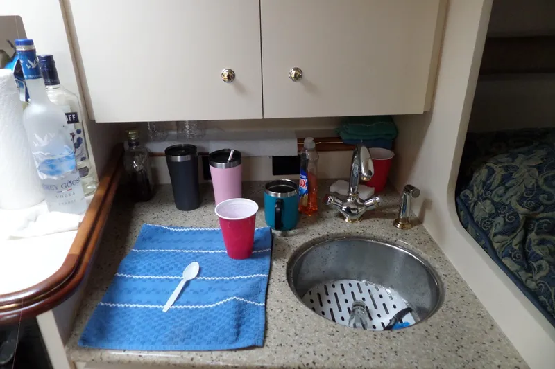 Slide: The Image of 2003 Cruisers Yachts 3275 Express kitchenette with sink, cups, and bottles on counter. - 37