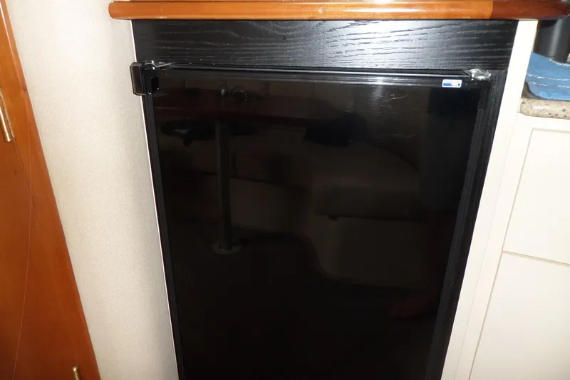 Slide: The Image of 2003 Cruisers Yachts 3275 Express interior with compact black refrigerator. - 38