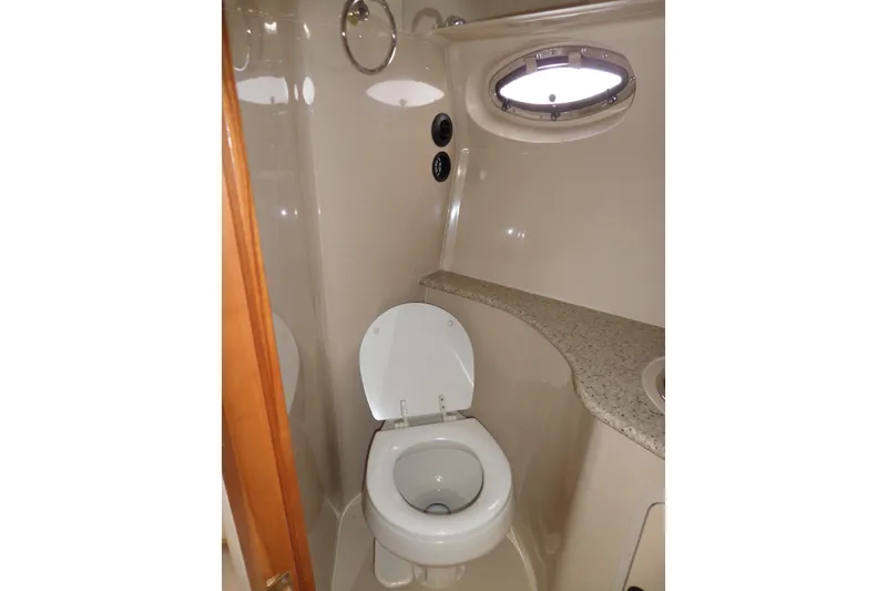 Slide: The Image of 2003 Cruisers Yachts 3275 Express bathroom with toilet and porthole window. - 47