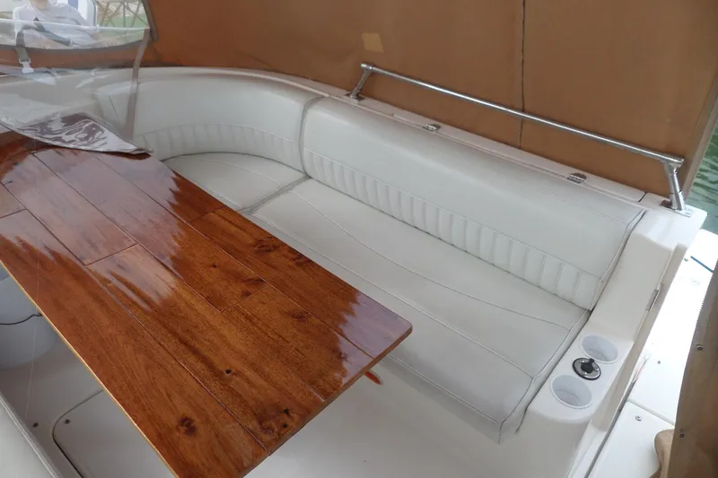 Slide: The Image of 2003 Cruisers Yachts 3275 Express interior with white seating and polished wooden table. - 7