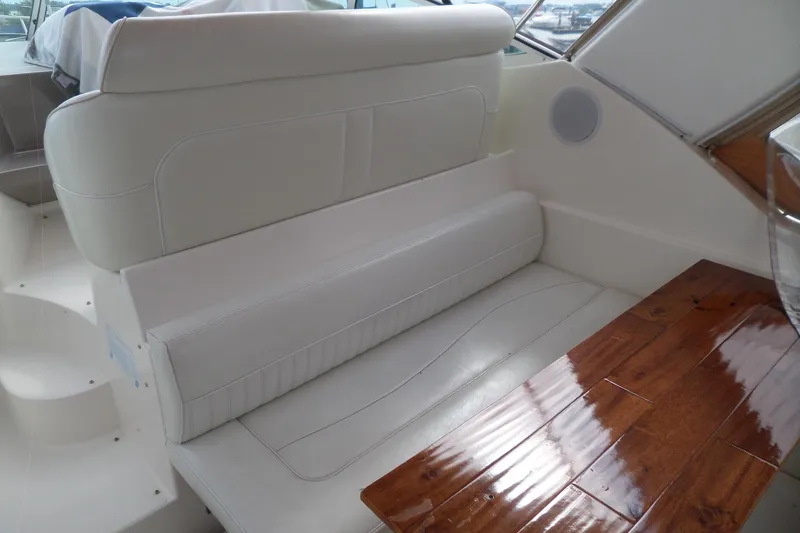 Slide: The Image of 2003 Cruisers Yachts 3275 Express interior with white seating and wooden table. - 9