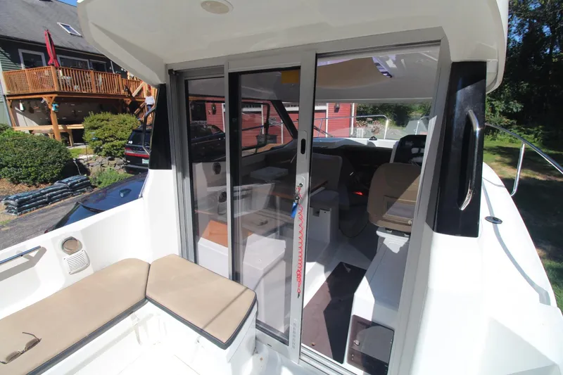 Slide: The Image of 2017 Jeanneau NC Sport 695 boat with sliding glass doors and cushioned seating. - 11
