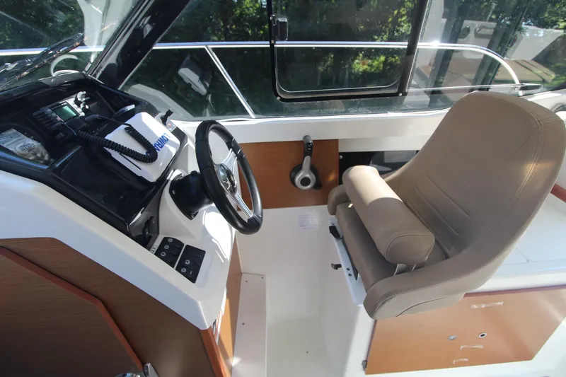 Slide: The Image of 2017 Jeanneau NC Sport 695 helm with steering wheel and captain's chair. - 13