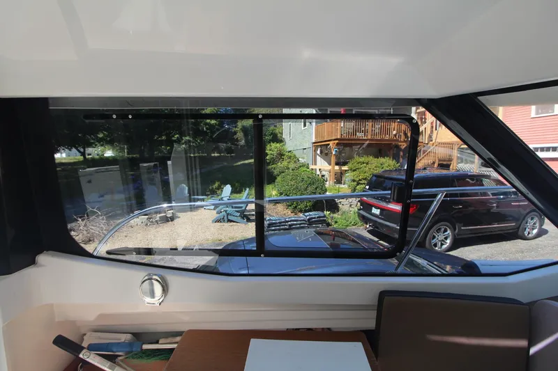 Slide: The Image of Interior view from 2017 Jeanneau NC Sport 695 boat, showing window and outdoor scenery. - 15