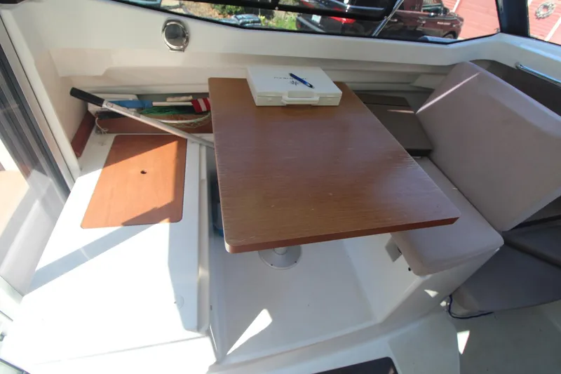 Slide: The Image of 2017 Jeanneau NC Sport 695 interior with wooden table and seating area. - 18