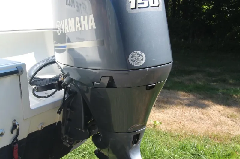 Slide: The Image of Yamaha 150 outboard motor on 2017 Jeanneau NC Sport 695 boat, parked on grass. - 4