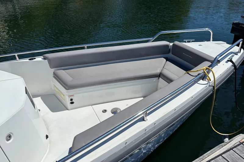 Slide: The Image of 2020 Axopar 28 Cabin Aft Cabin boat with gray seating, docked on calm water. - 10