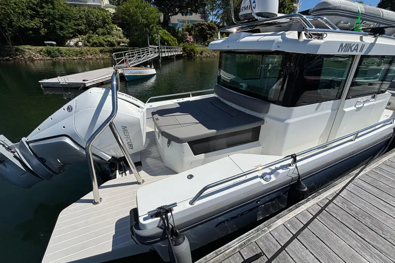 Slide: The Image of 2020 Axopar 28 Cabin Aft Cabin boat docked, featuring Mercury outboard engine. - 14