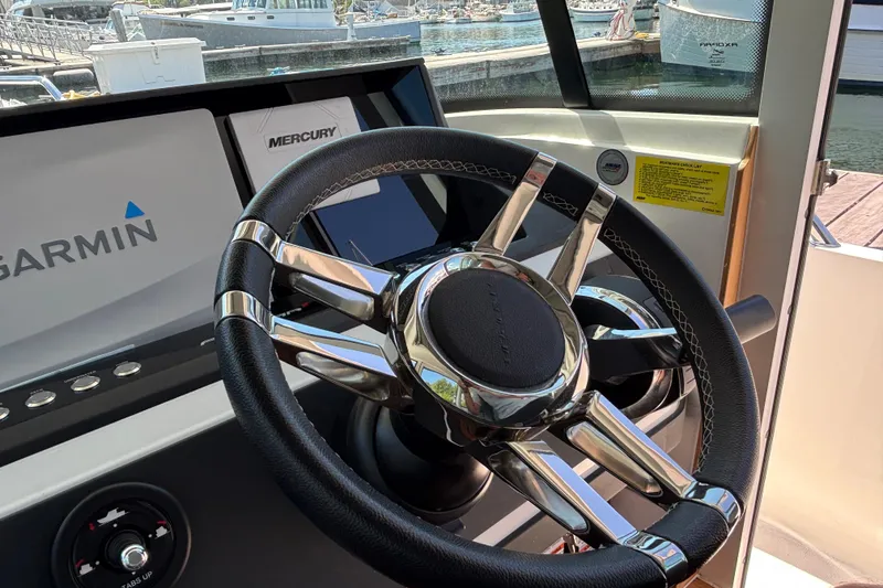 Slide: The Image of Steering wheel and dashboard of 2020 Axopar 28 Cabin Aft Cabin boat with Garmin display. - 17