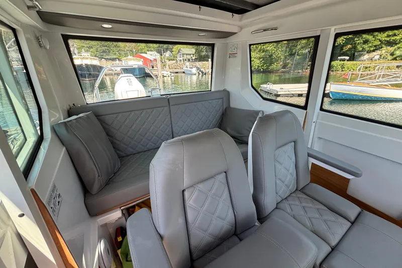 Slide: The Image of Interior of 2020 Axopar 28 Cabin Aft Cabin with gray seating and waterfront view. - 18
