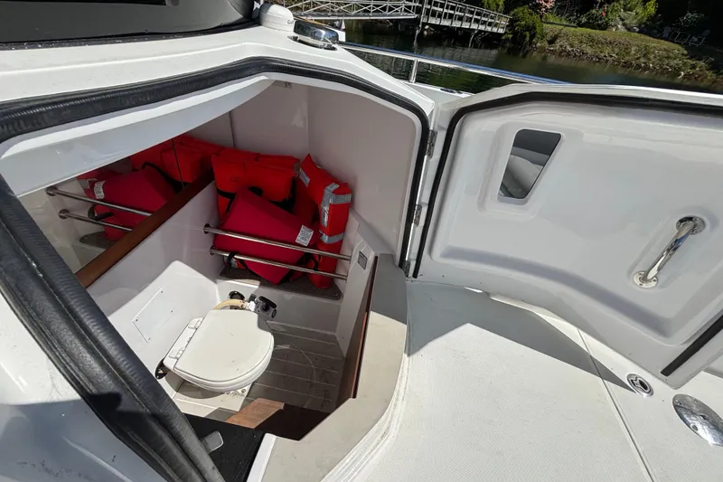 Slide: The Image of 2020 Axopar 28 Cabin Aft Cabin interior with life jackets and toilet. - 21