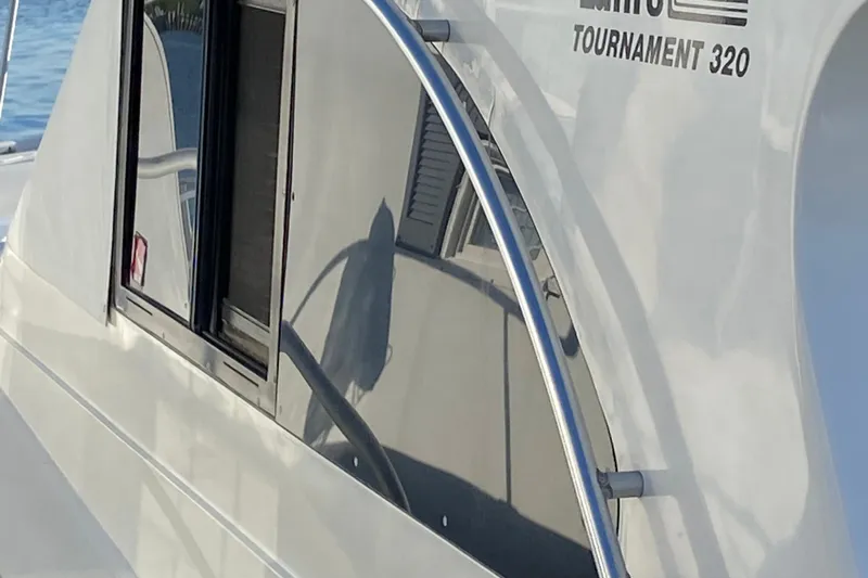 Slide: The Image of Close-up of a 1992 Luhrs Tournament 320 Convertible boat exterior with window and railing. - 12