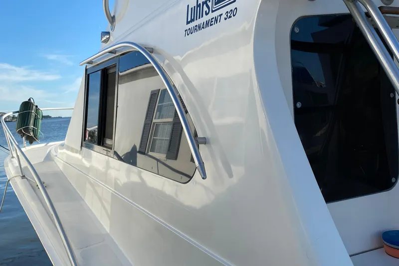 Slide: The Image of 1992 Luhrs Tournament 320 Convertible boat docked by the water. - 13