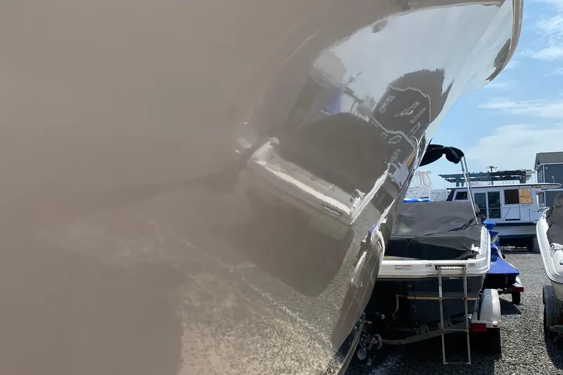 Slide: The Image of 1992 Luhrs Tournament 320 Convertible boat in storage, reflecting nearby vessels. - 19