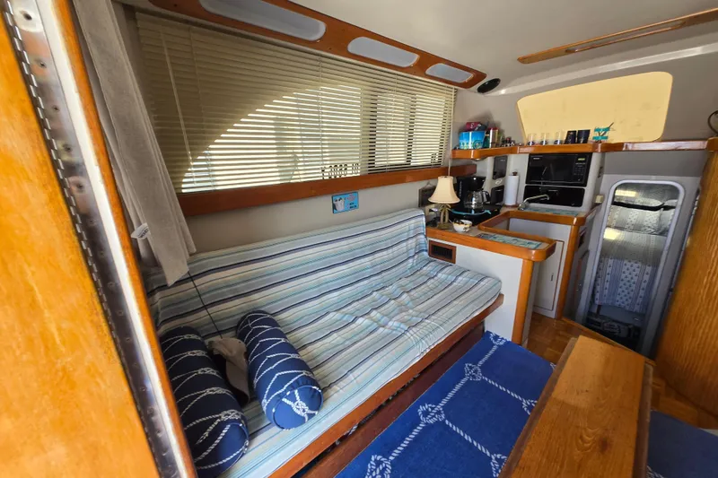 Slide: The Image of Interior of 1992 Luhrs Tournament 320 Convertible with striped seating and compact kitchen area. - 2