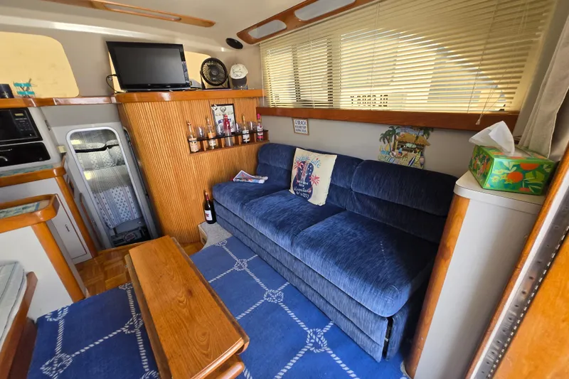 Slide: The Image of Interior of 1992 Luhrs Tournament 320 Convertible with blue sofa and wooden accents. - 3