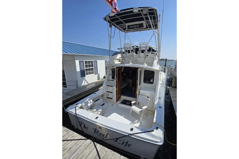 Slide: The Image of 1992 Luhrs Tournament 320 Convertible boat docked, featuring spacious deck and flybridge. - 4