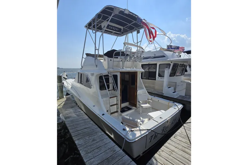 Slide: The Image of 1992 Luhrs Tournament 320 Convertible docked, featuring flybridge and spacious deck. - 9