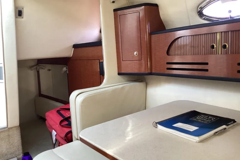 Slide: The Image of Interior of 2004 Sea Ray 280 Sundancer with wood cabinetry and seating area. - 12