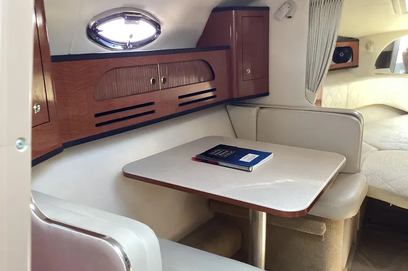 Slide: The Image of Interior of 2004 Sea Ray 280 Sundancer with dining area and wooden cabinetry. - 16