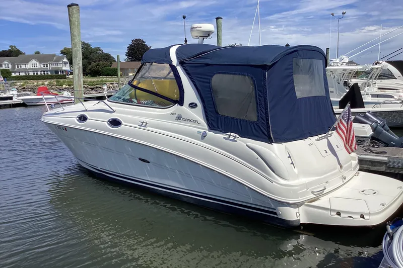 Slide: The Image of 2004 Sea Ray 280 Sundancer boat docked with blue canopy and American flag. - 3