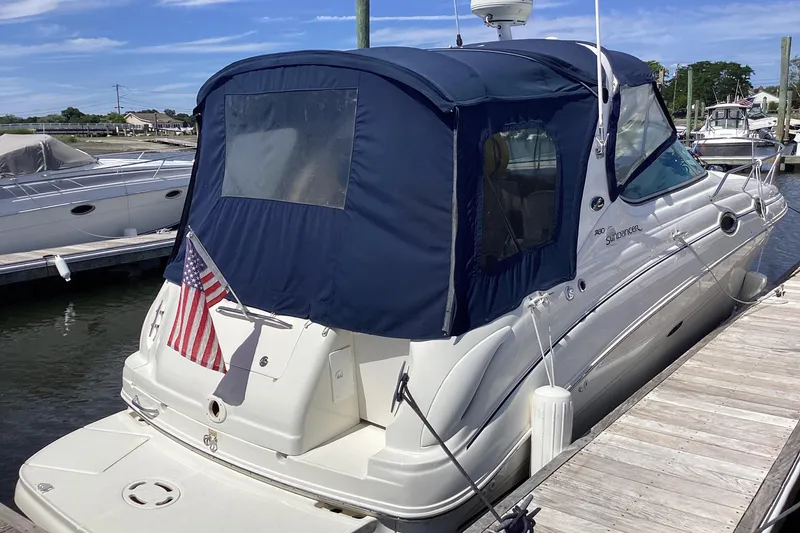 Slide: The Image of 2004 Sea Ray 280 Sundancer docked with blue canopy and American flag. - 4