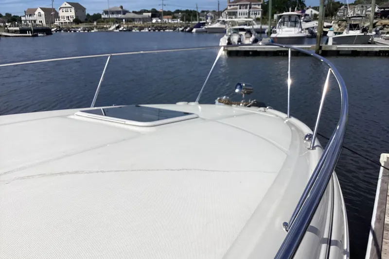 Slide: The Image of 2004 Sea Ray 280 Sundancer yacht docked at a marina, showcasing sleek bow design. - 6