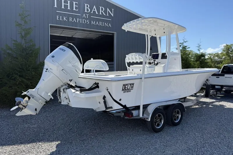 Slide: The Image of 2026 Delta D245 boat on trailer at Elk Rapids Marina, featuring powerful outboard motor. - 1