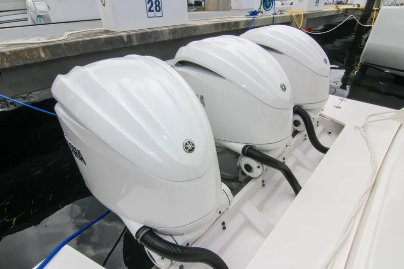 Slide: The Image of Triple outboard engines on a 2023 Regal 38 SAV boat docked at a marina. - 10