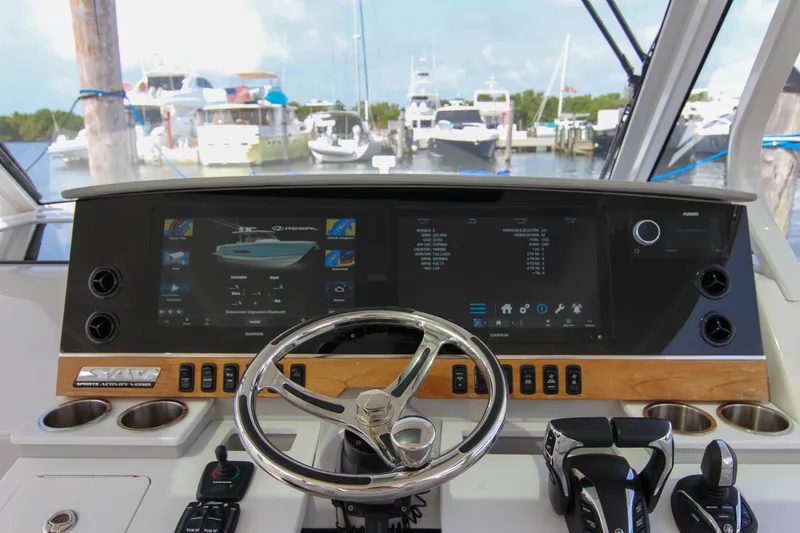 Slide: The Image of 2023 Regal 38 SAV helm with advanced navigation display and controls at marina. - 11