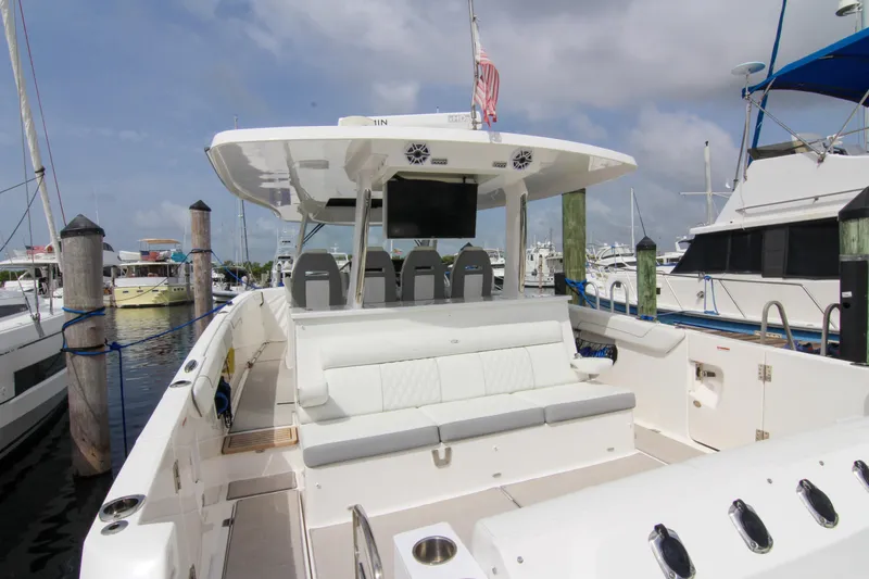 Slide: The Image of 2023 Regal 38 SAV luxury boat docked at marina, featuring spacious seating and modern design. - 17